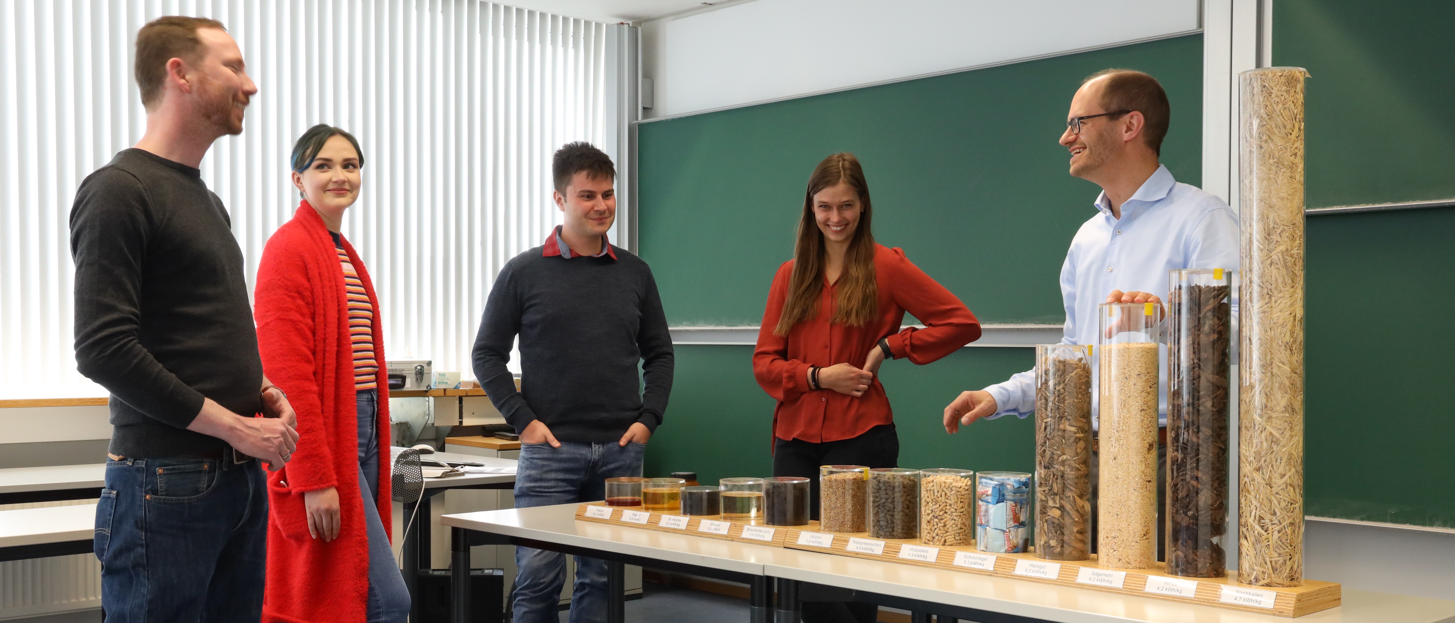 Professor shows a group of students different materials to represent the watt-hours per kilogram that can be obtained from each material