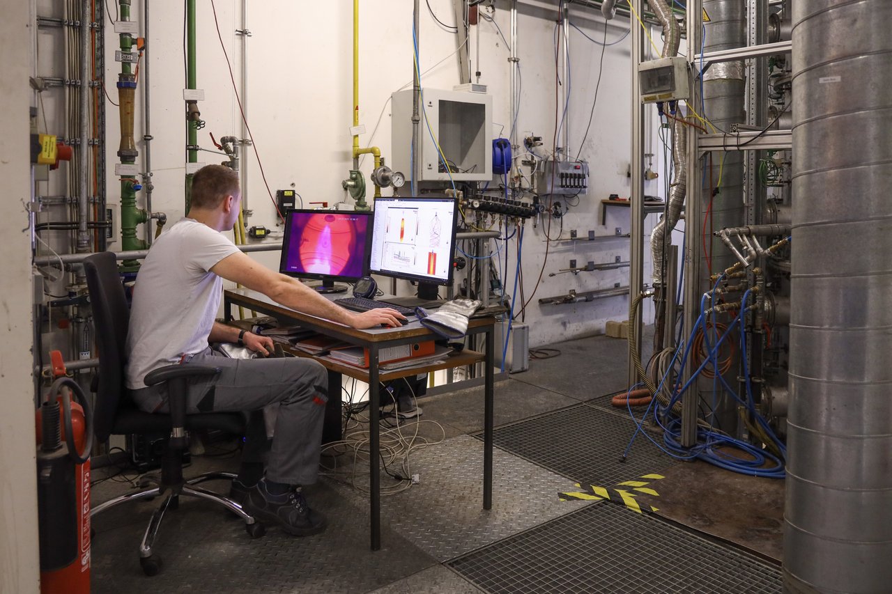 Ein Studierender sitzt vor zwei Bildschirmen in einem Labor und führt eine Simulation durch